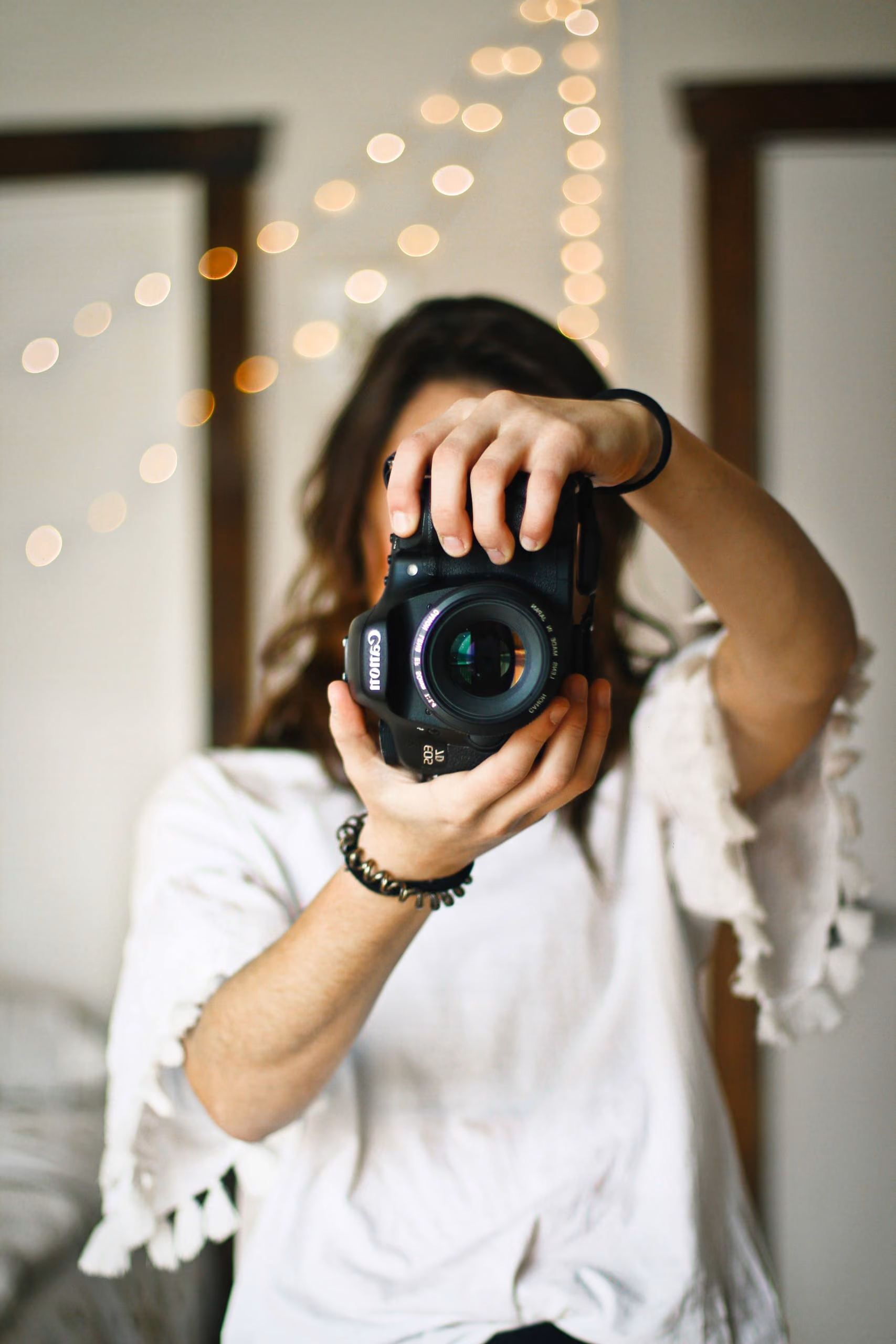A photographer holding her camera up to her face