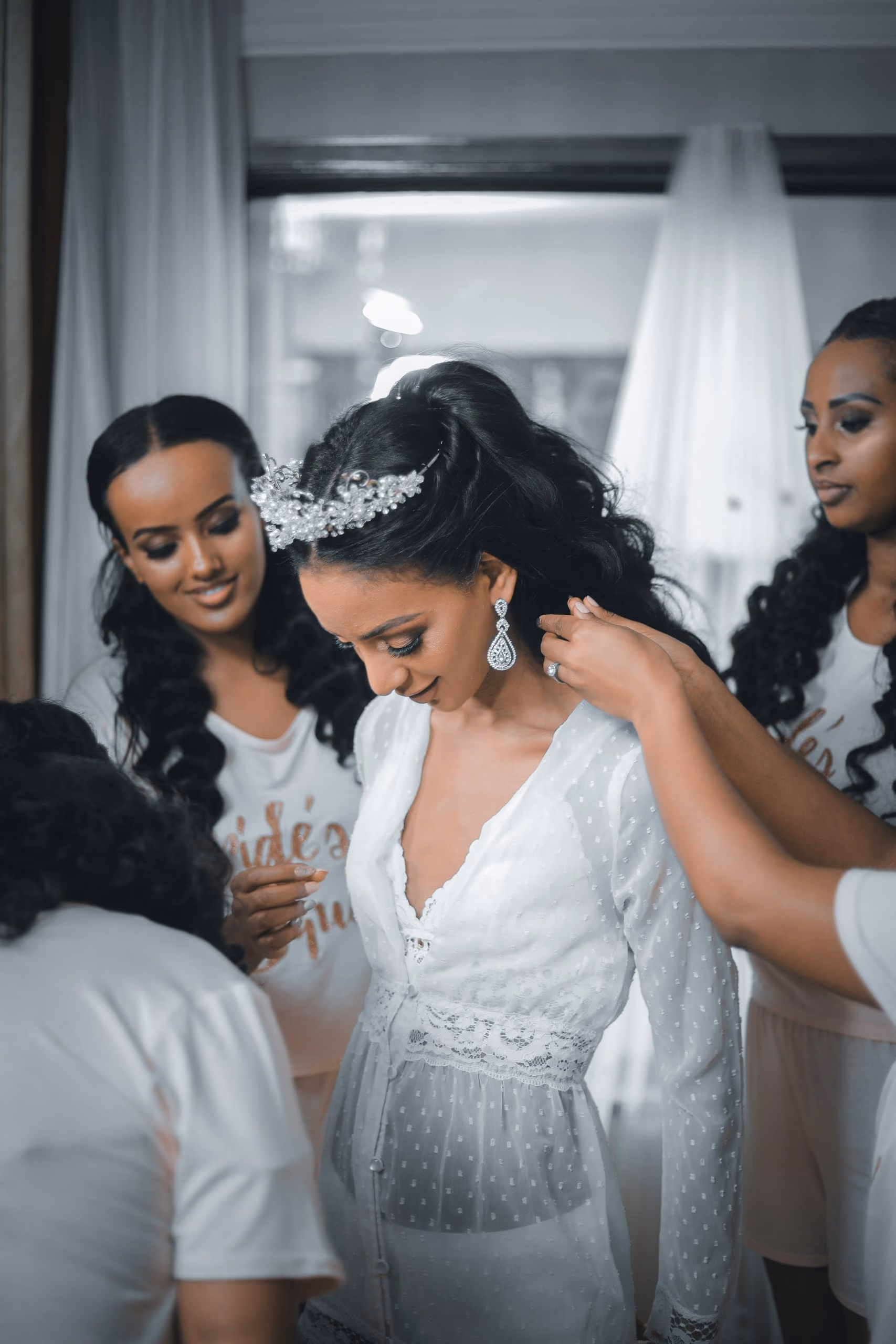 Bridesmaids helping the bride with her necklace before the ceremony